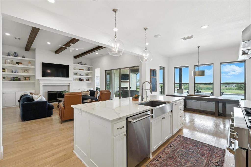148 Overlook Drive Aledo, TX 76008 - Photo 17 of 40 a large white kitchen with a stove a sink dishwasher a dining table and chairs with wooden floor