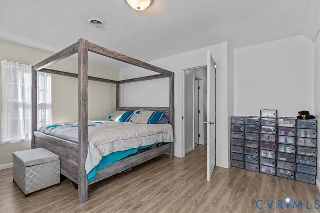 a bedroom with a large bed and a wooden floor