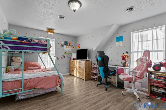 a bedroom with bed and a wooden floor