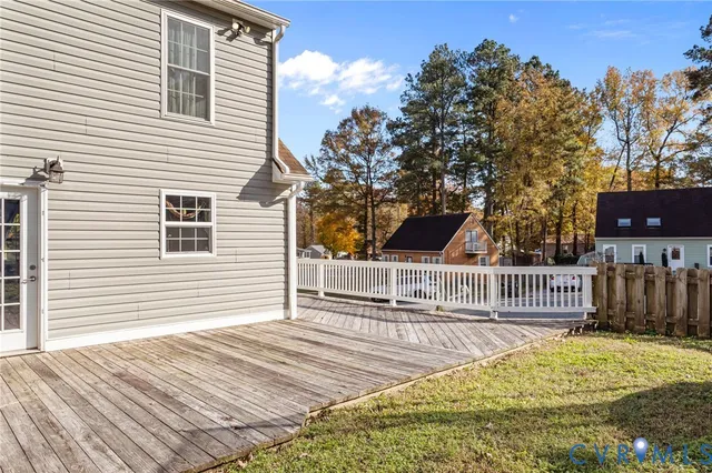 a view of backyard with deck and a garden
