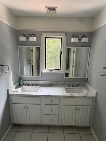 a bathroom with a sink vanity and mirror