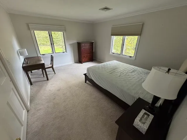 a bedroom with a bed and a lamp on desk