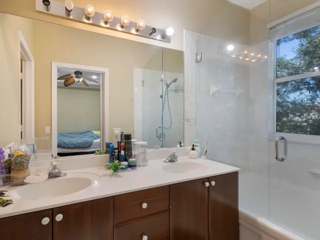a bathroom with a double vanity sink a mirror and shower