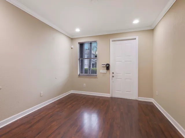 a view of a room with wooden floor and white walls