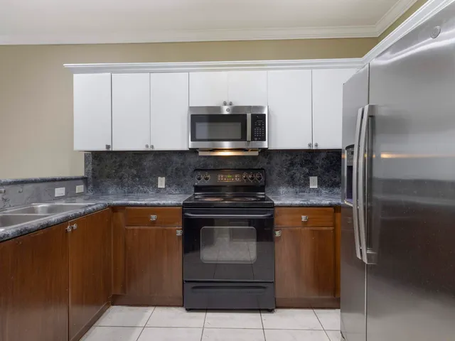 a kitchen with cabinets a sink and stainless steel appliances