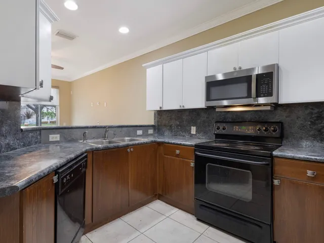 a kitchen with stainless steel appliances granite countertop a stove microwave and sink