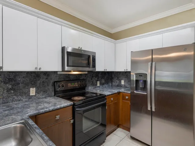 a kitchen with granite countertop a sink and stainless steel appliances