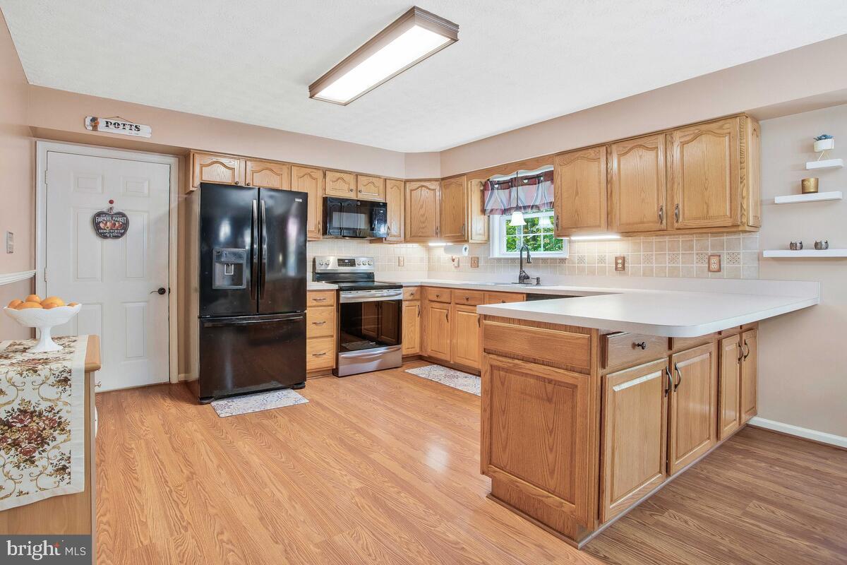 165 Ball Road St. Leonard, MD 20685 - Photo 21 of 55 a kitchen with stainless steel appliances granite countertop a sink stove refrigerator and cabinets