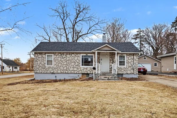 a front view of a house with a yard covered with snow