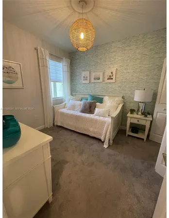 a spacious bedroom with a bed and a chandelier