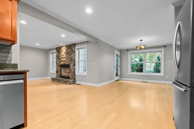 a view of an empty room with a fireplace and a window