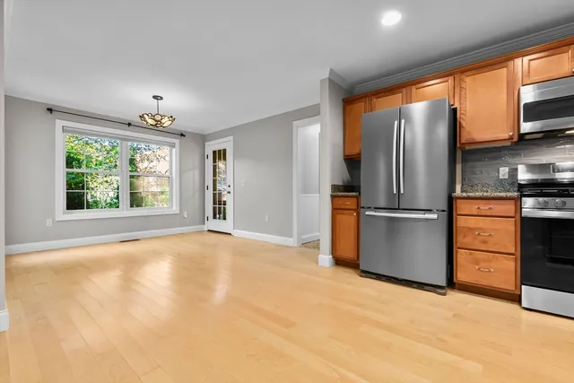 a view of kitchen with stainless steel appliances kitchen island a large window and a refrigerator