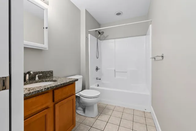 a bathroom with a granite countertop sink a toilet and shower