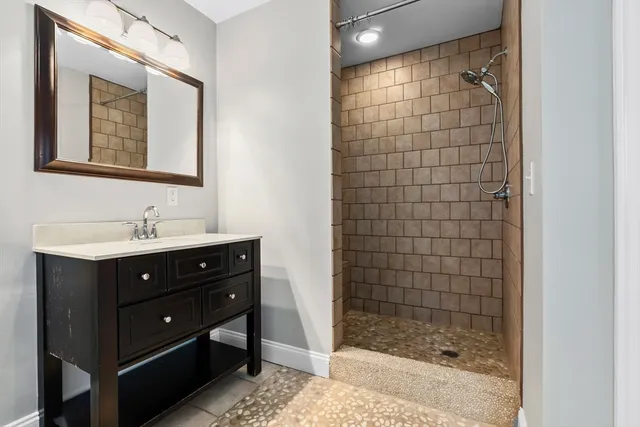 a bathroom with a sink shower and a mirror