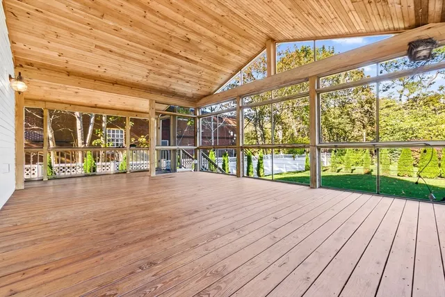 a view of a patio with wooden floor and garden