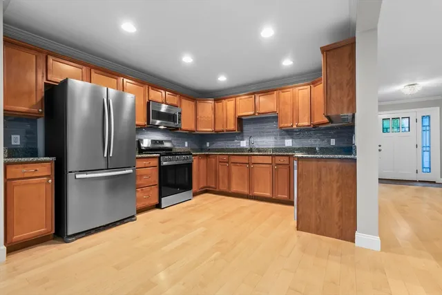 a kitchen with stainless steel appliances granite countertop a refrigerator a sink a stove a microwave and island