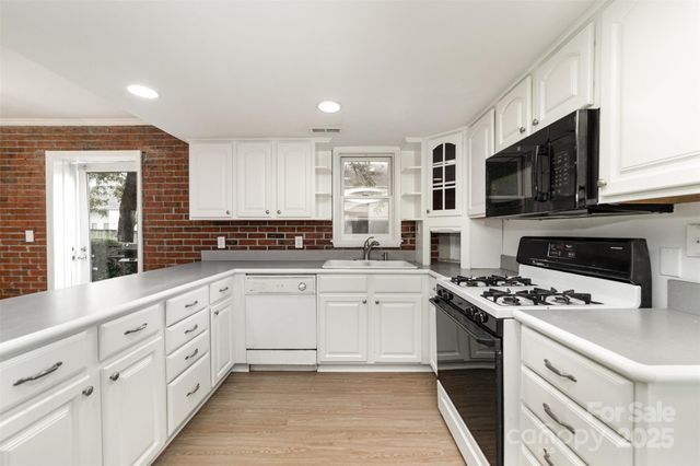 a kitchen with granite countertop cabinets stainless steel appliances a sink and a counter top space
