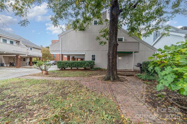 a tree in front of a white house