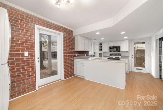 a view of kitchen with stainless steel appliances refrigerator oven and cabinets