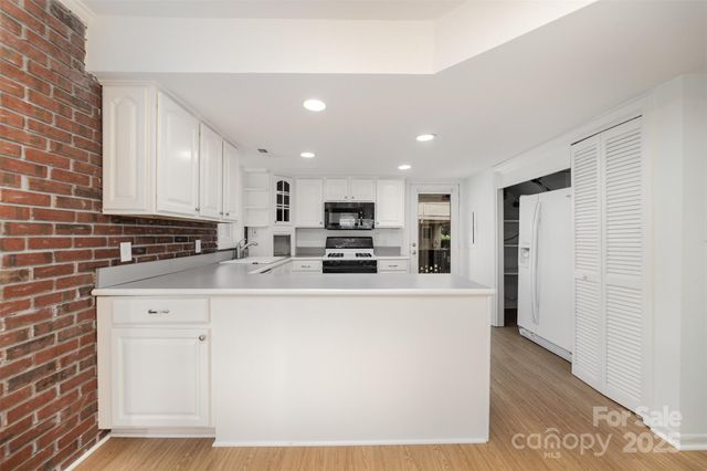 a kitchen with stainless steel appliances a refrigerator sink and white cabinets