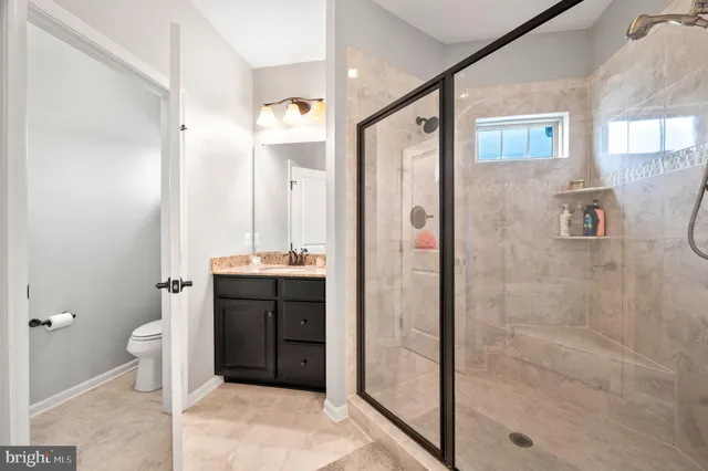 a bathroom with a granite countertop sink shower and a mirror