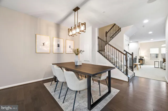 a kitchen with granite countertop a table chairs stove a refrigerator and microwave