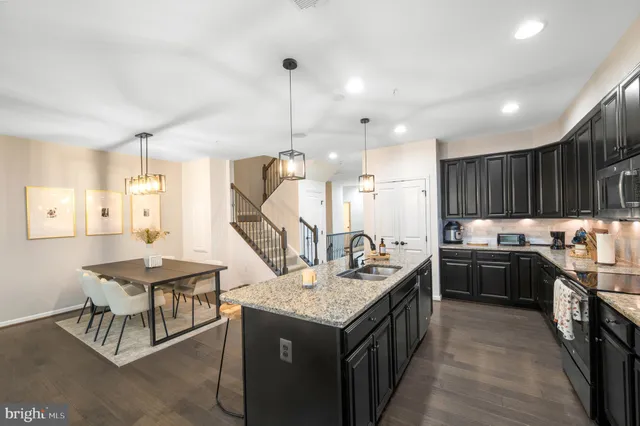 a kitchen with stainless steel appliances granite countertop a sink a refrigerator and a stove