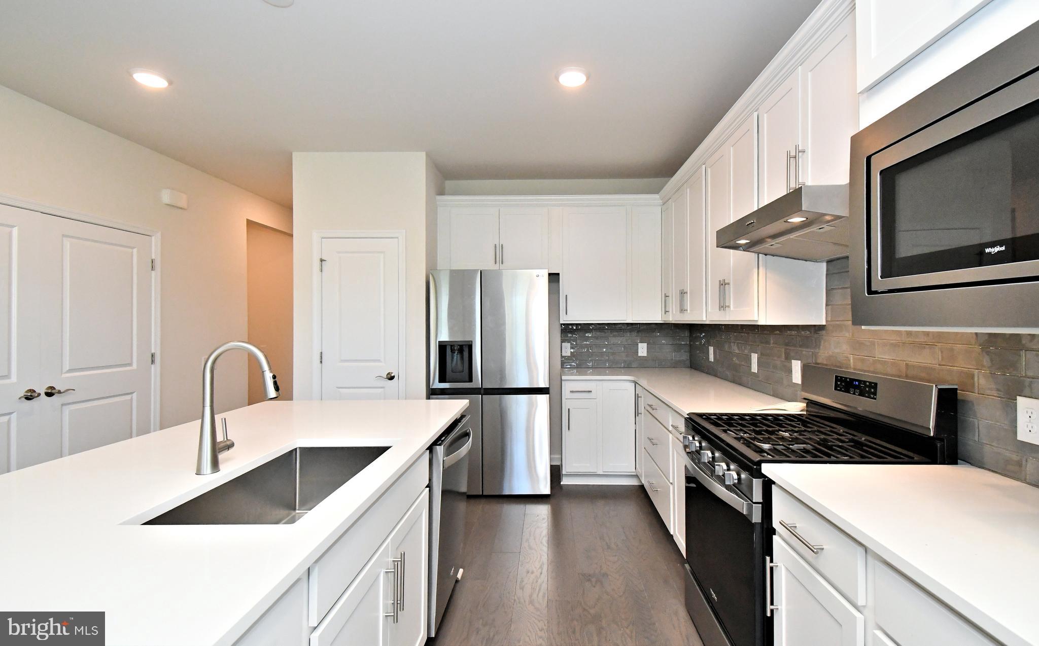 1024 Wright Street Hatfield, PA 19440 - Photo 9 of 68 a kitchen with stainless steel appliances granite countertop a sink a stove a refrigerator cabinets and a stove top oven with wooden floor