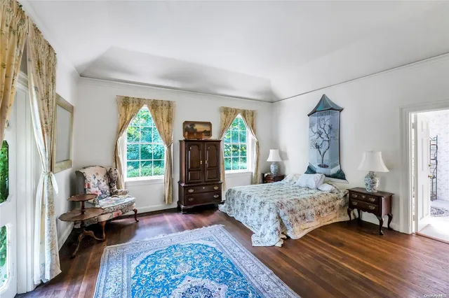 a bedroom with a bed and large windows