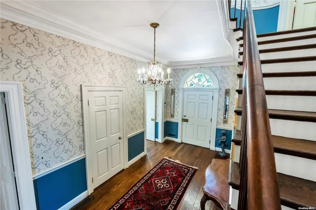 a view of a hallway with furniture and chandelier