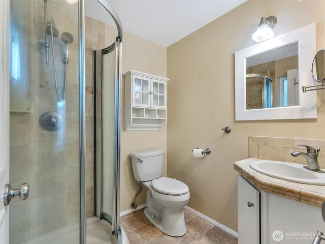 a bathroom with a toilet sink double vanity and mirror