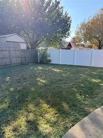 a view of a backyard with a small cabin and a chair
