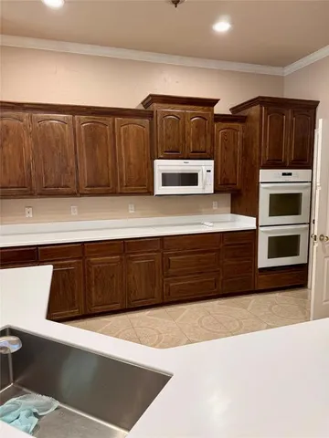 a kitchen with granite countertop a refrigerator and a stove top oven