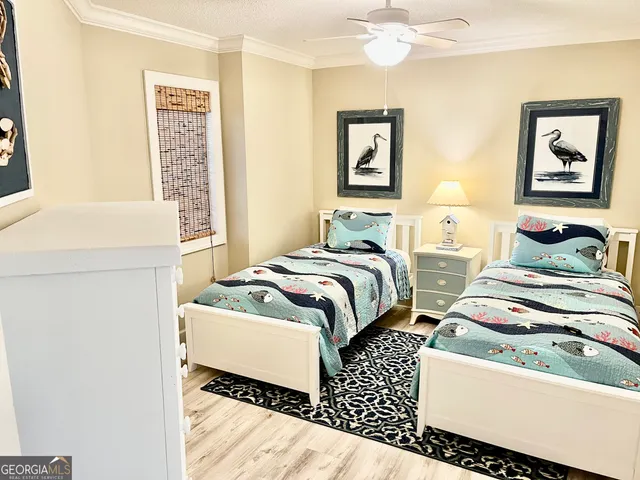 a bedroom with two beds and painting on the wall