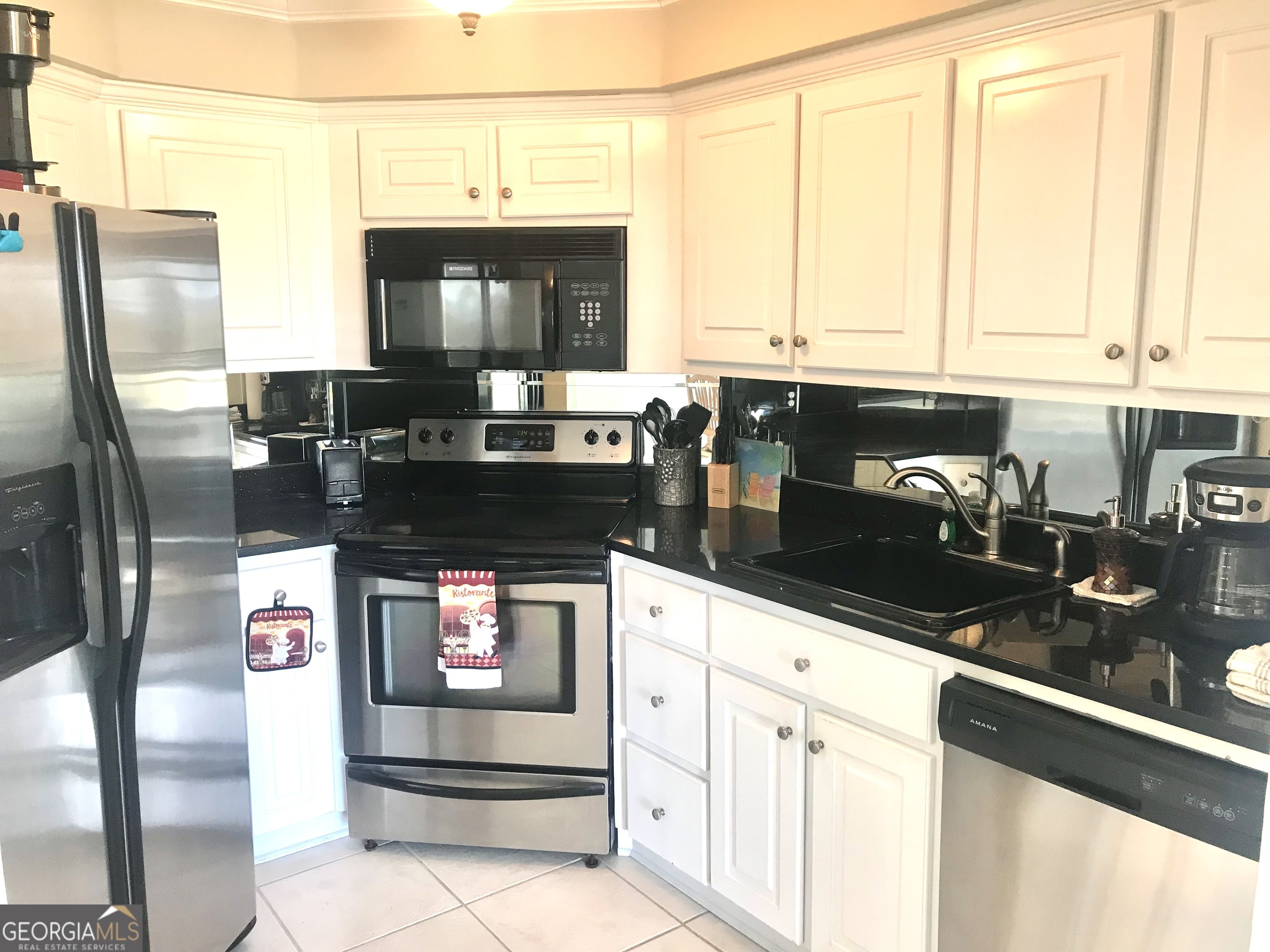 372 Moss Oak Circle St. Simons, GA 31522 - Photo 9 of 44 a kitchen with stainless steel appliances granite countertop a stove a sink and a microwave