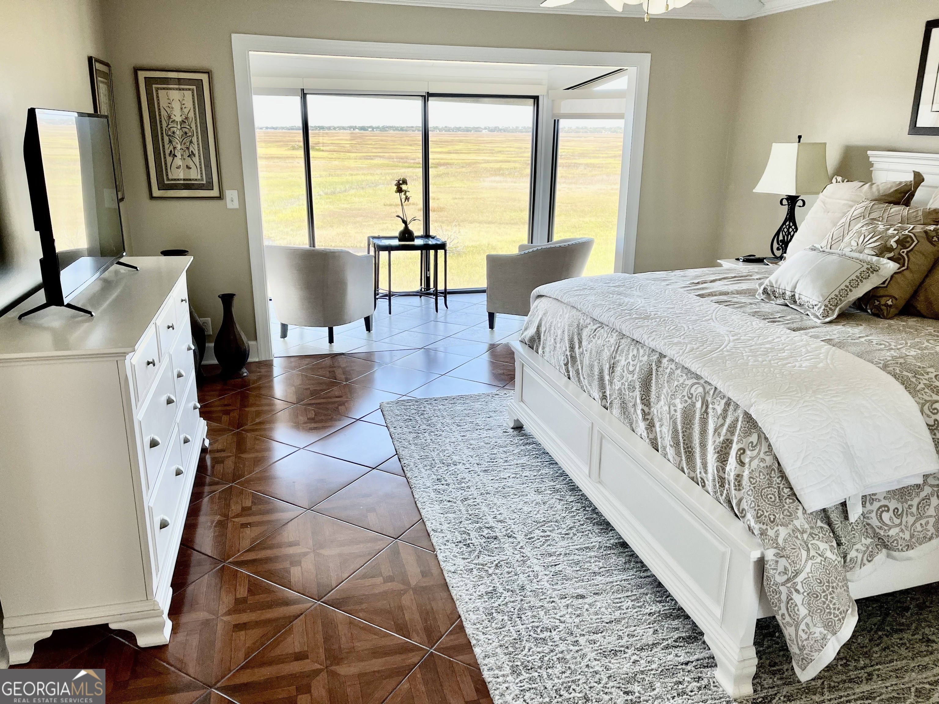 372 Moss Oak Circle St. Simons, GA 31522 - Photo 10 of 44 a spacious bedroom with a bed a couch and a large window