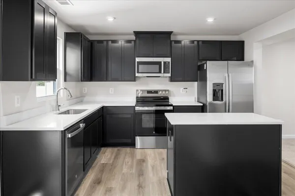 a kitchen with stainless steel appliances a sink stove and refrigerator