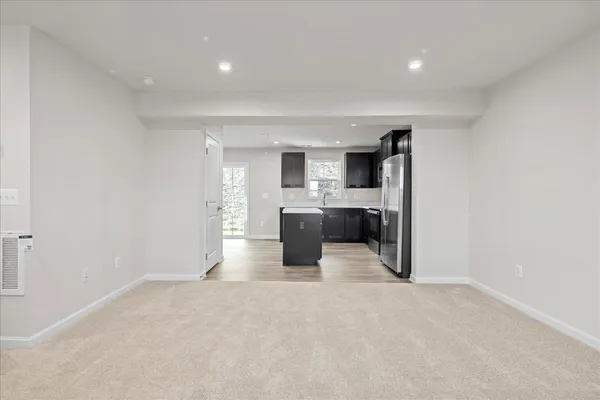 a view of an empty room with a fireplace and a window