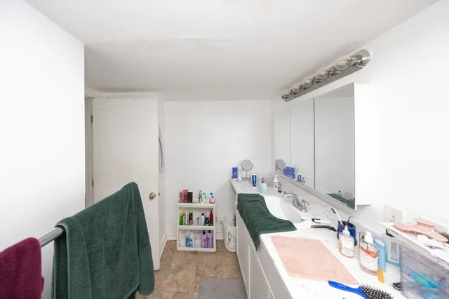 a bathroom with a tub sink and mirror