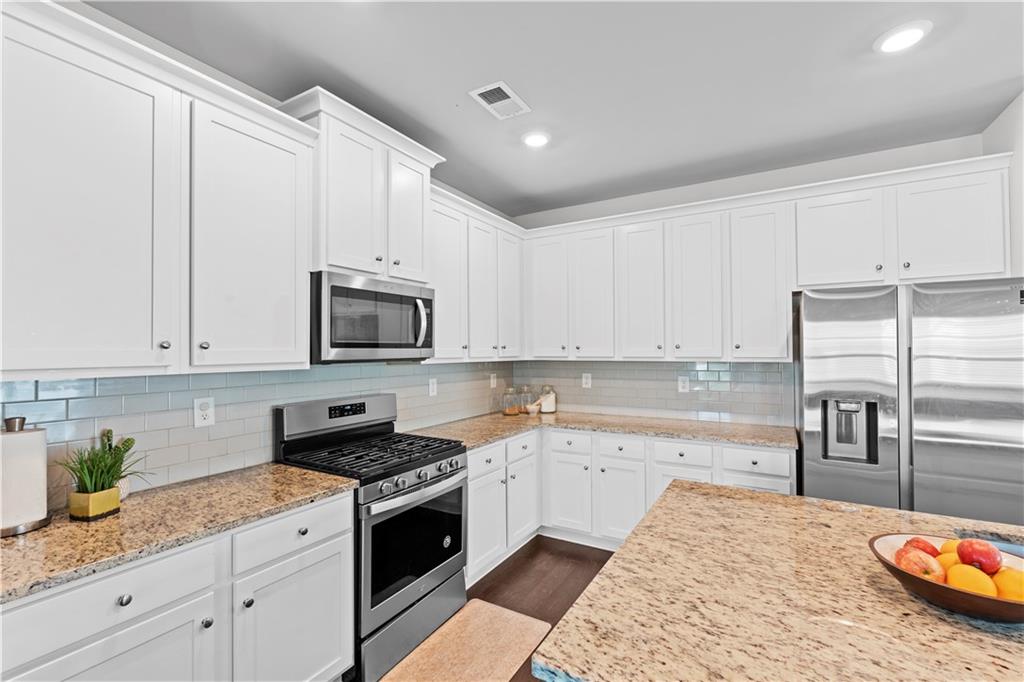 1030 Shy Lane Marietta, GA 30060 - Photo 10 of 50 a kitchen with granite countertop a sink stainless steel appliances and white cabinets