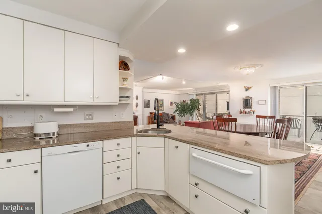 a kitchen with white cabinets and sink