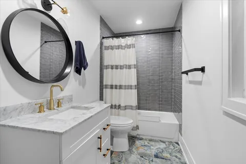 a bathroom with a granite countertop sink toilet and shower
