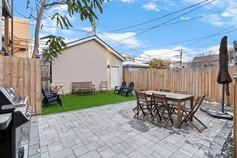 a table and chairs sitting in backyard of house