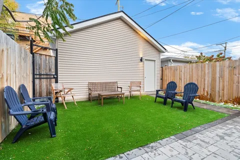 a backyard of a house with table and chairs