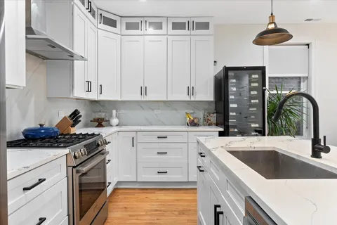a kitchen with stainless steel appliances granite countertop a sink stove and white cabinets