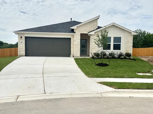 a front view of a house with a yard and garage