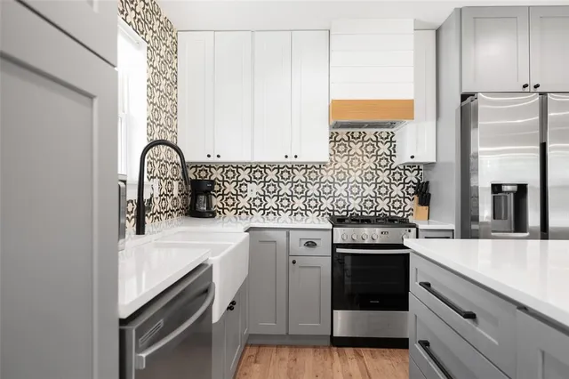 a kitchen with stainless steel appliances granite countertop a stove and a refrigerator with white cabinets