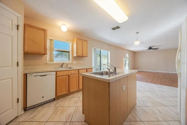 a kitchen with a sink window and cabinets