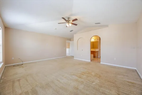 an empty room with a ceiling fan and window
