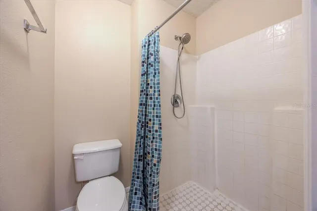 a bathroom with a toilet and a shower